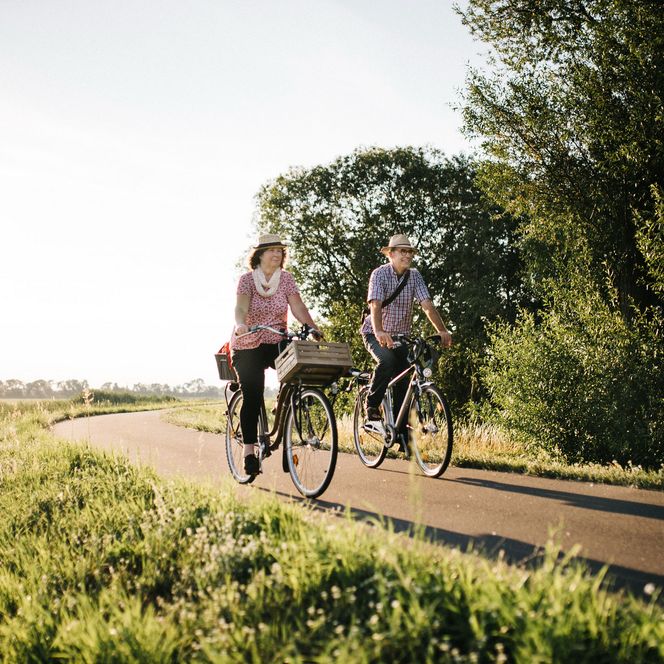 Älteres Paar auf Fahrrädern unterwegs auf einem Radweg im Havelland
