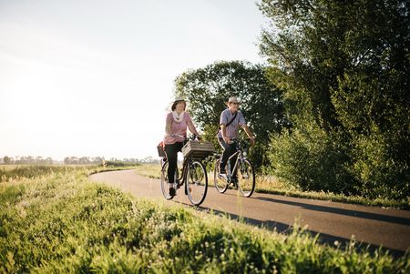 Älteres Paar auf Fahrrädern unterwegs auf einem Radweg im Havelland
