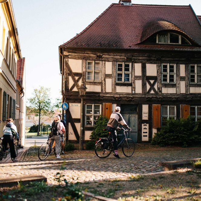 Radfahrer vor einem Fachwerkhaus auf dem Kirchberg in Rathenow