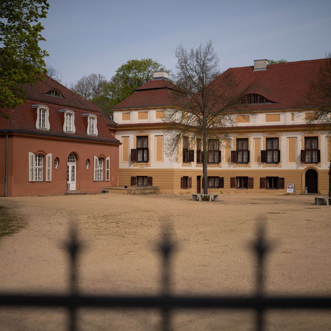 Blick über den Zaun auf den Vorplatz vom Schloss Caputh