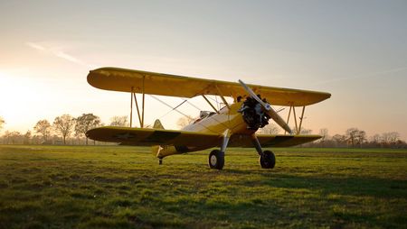 Gelber Doppeldecker Stearman auf dem Flugplatz Bienenfarm bei Sonnenuntergang