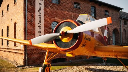 Gelbes Propellerflugzeug vor dem Otto-Lilienthal-Centrum Stölln