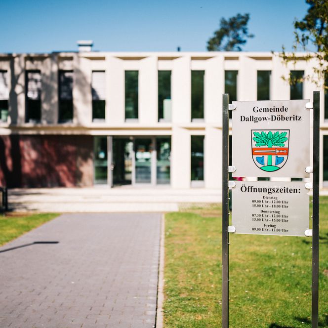 Nahaufnahme vom Öffnungszeitenschild vor dem Rathaus der Gemeinde Dallgow-Döberitz