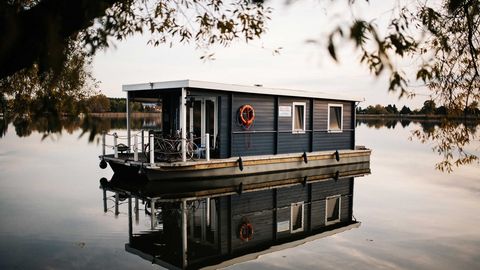 Ein Hausboot liegt in der Dämmerung am Ufer des Beetzsees