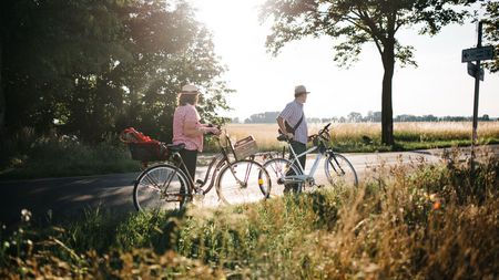 Älteres Paar mit Fahrrädern macht eine Pause am Havel-Radweg im Havelland 