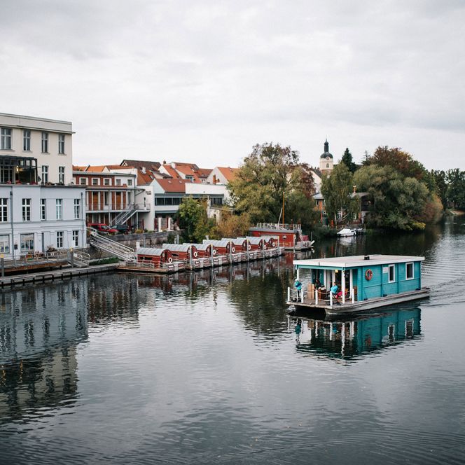 Türkises Hausboot fährt auf der Havel am Fonte in Brandenburg an der Havel vorbei