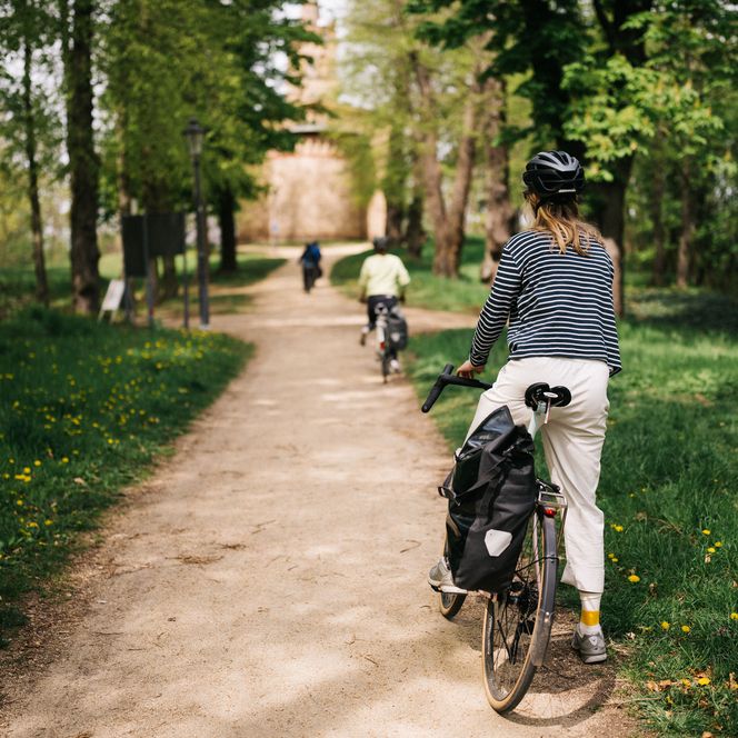 Radfahrerin im Park vor der Schinkelkirche Petzow